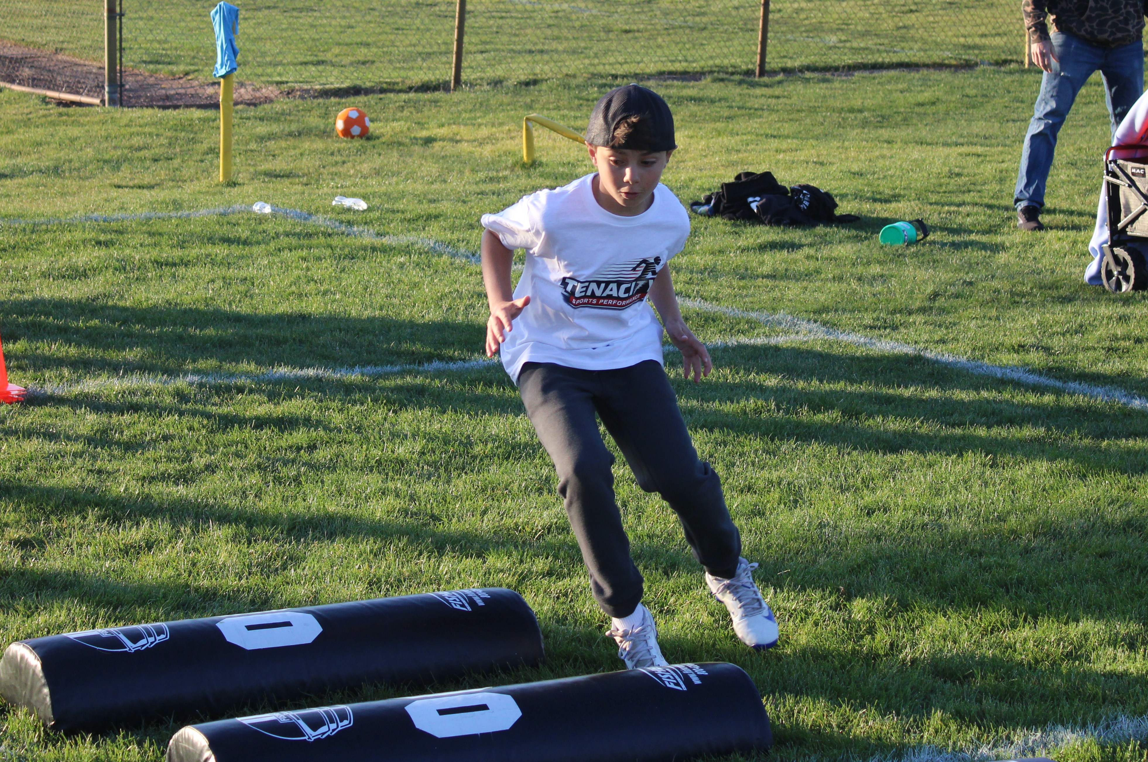 Tenacity athlete working on footwork and change of direction over agility bags