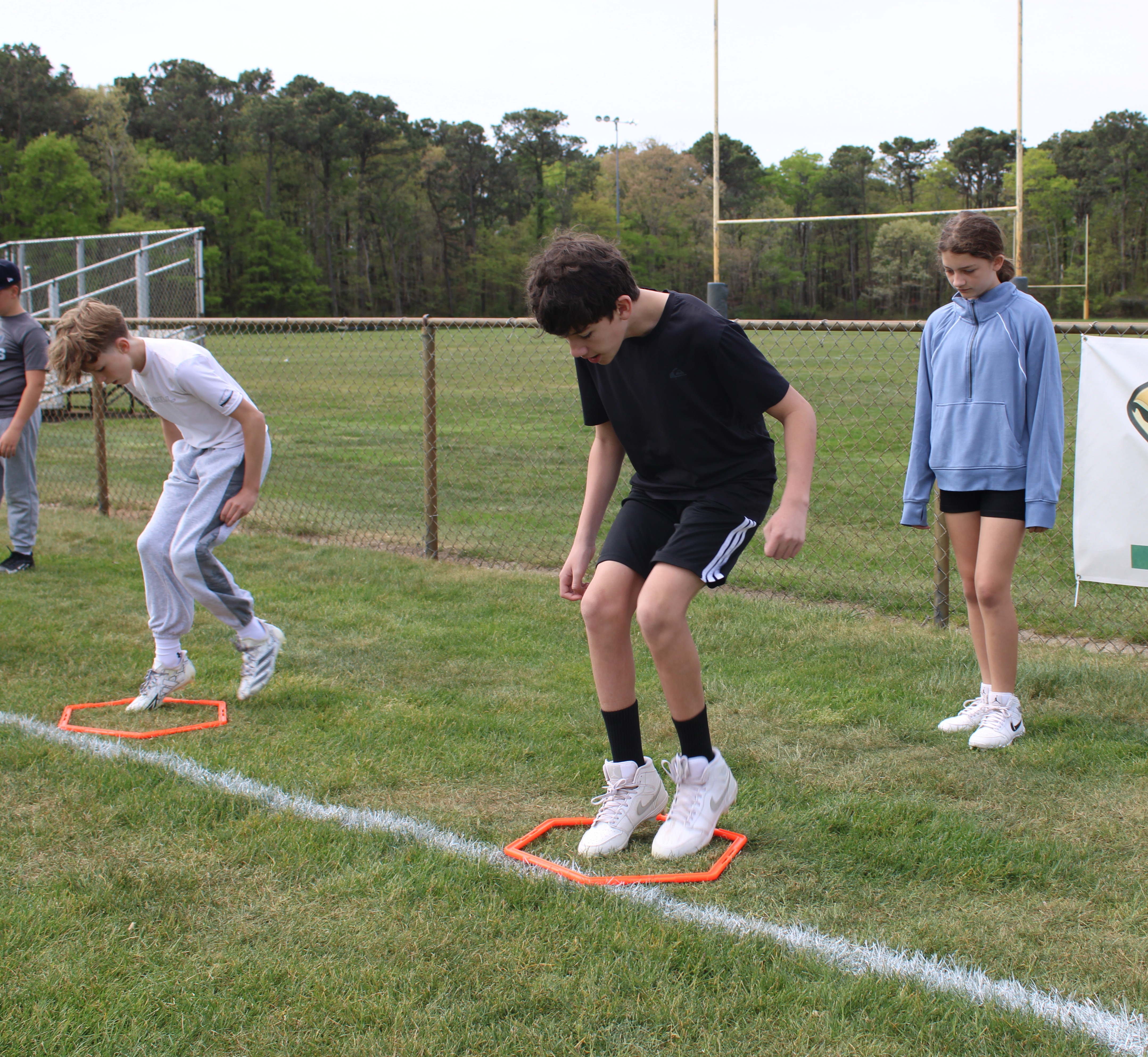 Older Tenacity athletes working on footwork and body control in agility squares
