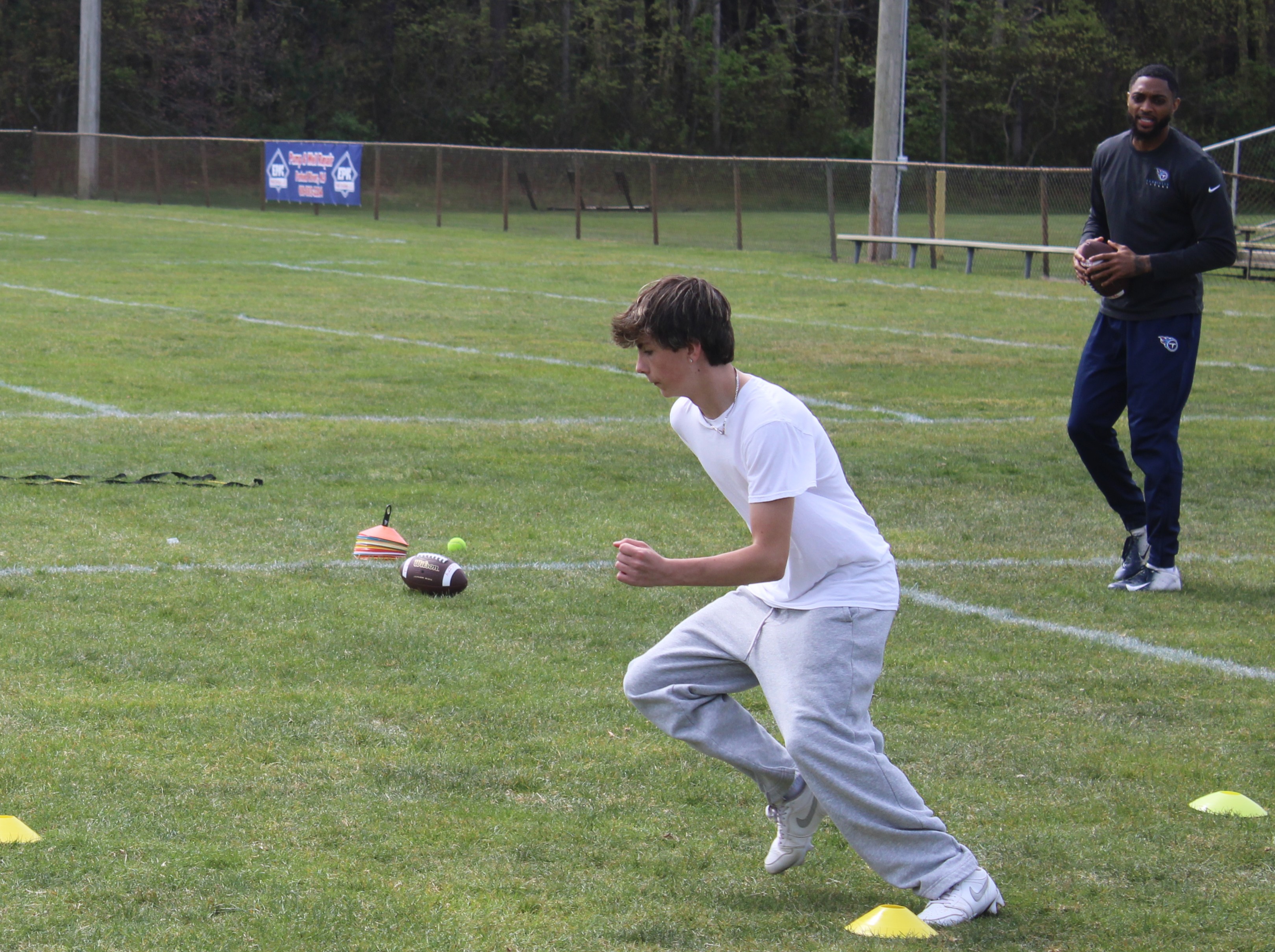 Tenacity athlete receiving focused private movement coaching on a football field